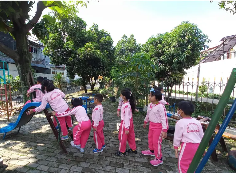 Anak-anak PAUD Asoka belajar sabar dan berbagi giliran saat antre bermain perosotan.